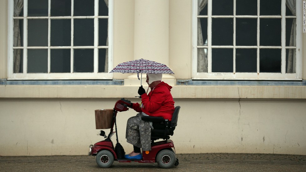 A woman passes along the seafront as the rain falls in Weston-Super-Mare, England, on Tuesday, May 14. 