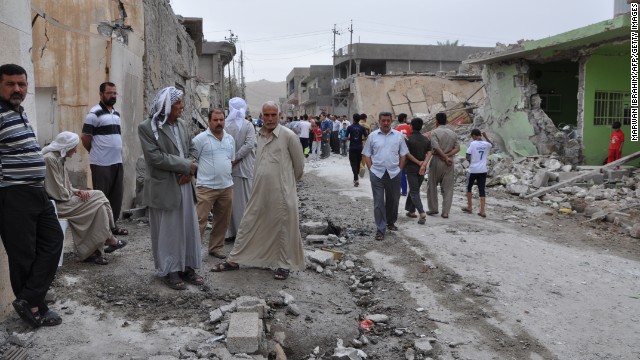Iraqis inspect damages at the site of two car bomb blasts in Tuz Khurmatu in the Salaheddine province, on May 21, 2013.