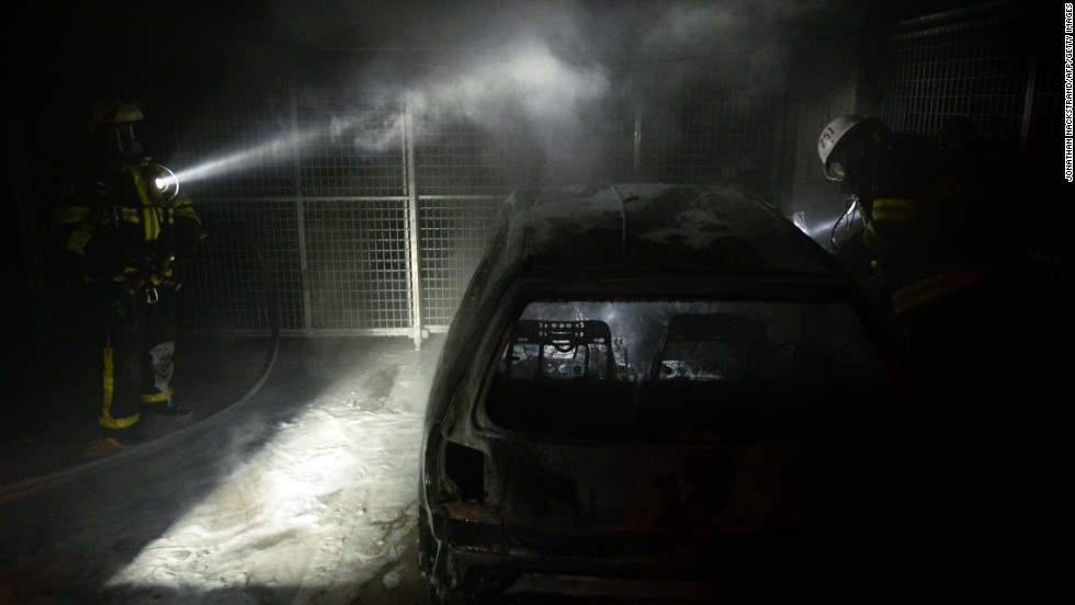 Firemen extinguish a burning car parked in an indoor garage in the Stockholm suburb of Tureberg on May 24.