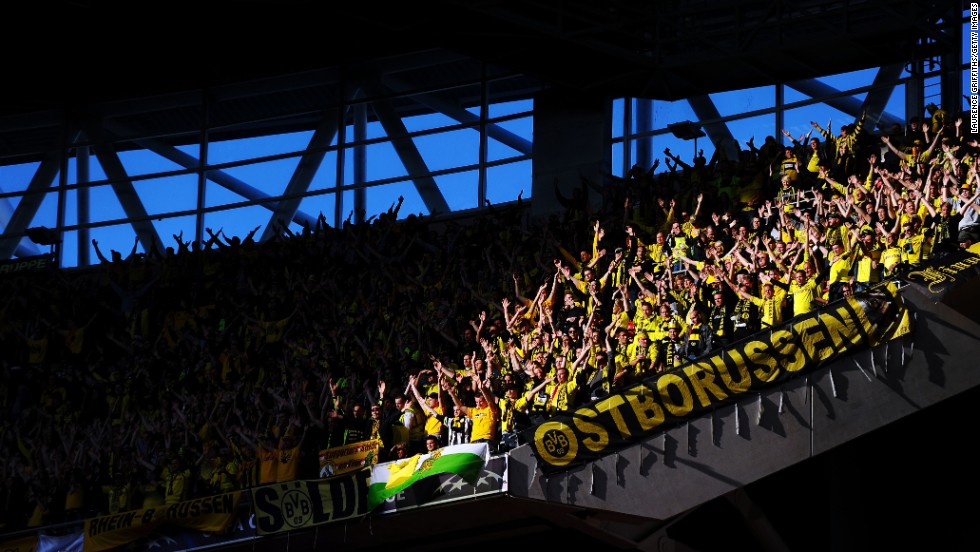 Borussia Dortmund fans in the upper deck of Wembley Stadium cheer for their team.