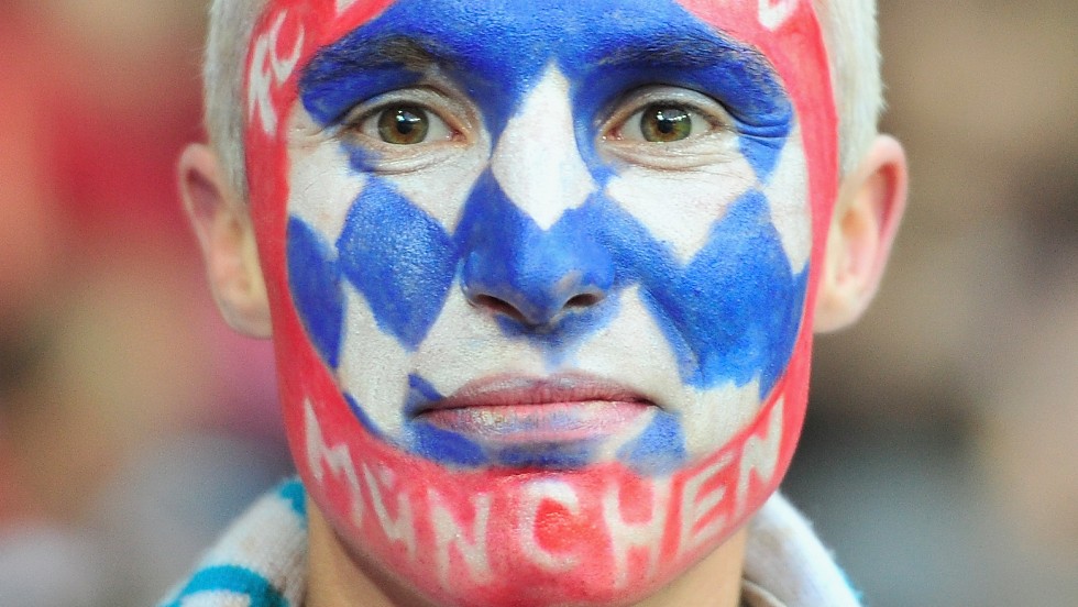 A fan of Bayern Munich wears face paint in support of his team during the match.