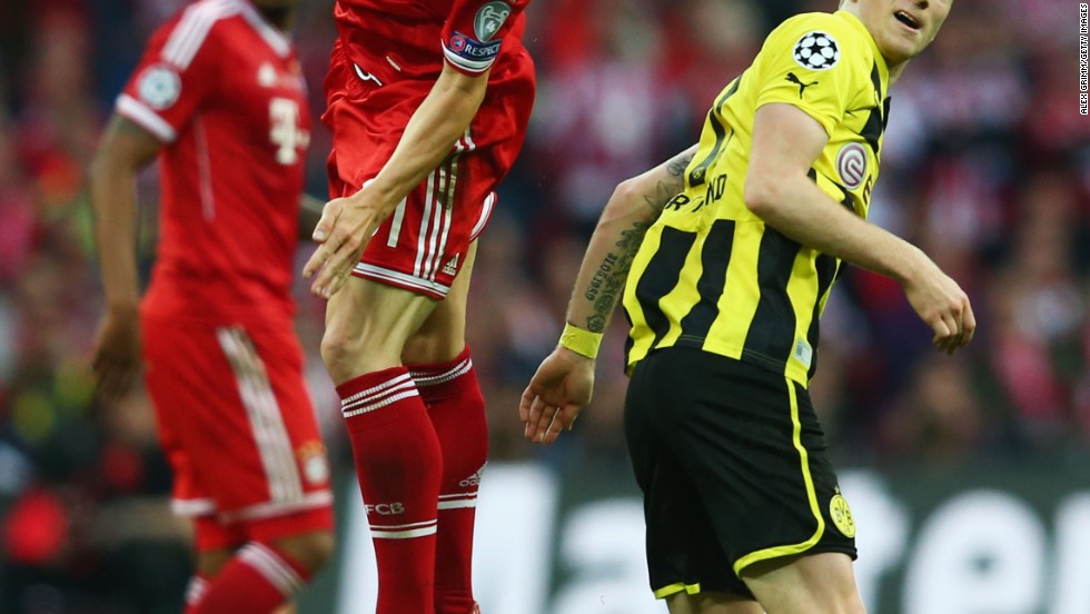 Bastian Schweinsteiger of Bayern performs a header against Marco Reus of Borussia Dortmund.