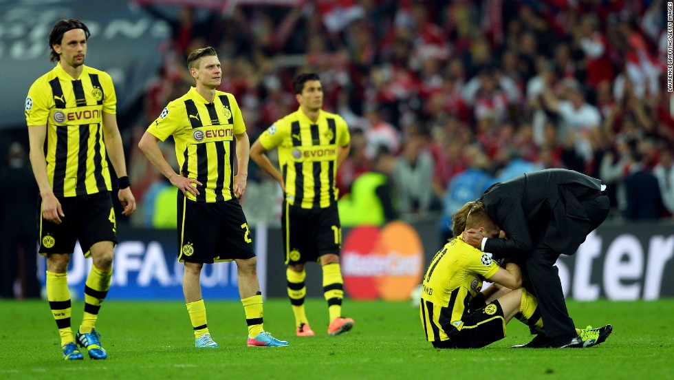 Head Coach Jurgen Klopp, right, of Borussia Dortmund consoles his players after losing to Bayern Munich in the championship match.