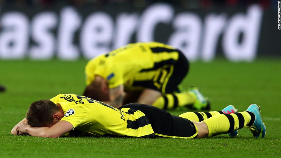 Dortmund players lie on the field in defeat after losing to Bayern 2-1.