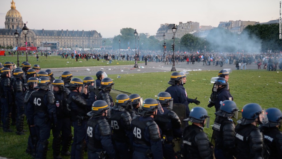 Riot police stand in a line facing protesters on May 26.