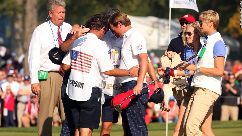 Watson, Webb Simpson and their caddies pray during the 39th Ryder Cup at Medinah, Illinois. They were later met by their wives, who also joined in the huddle.