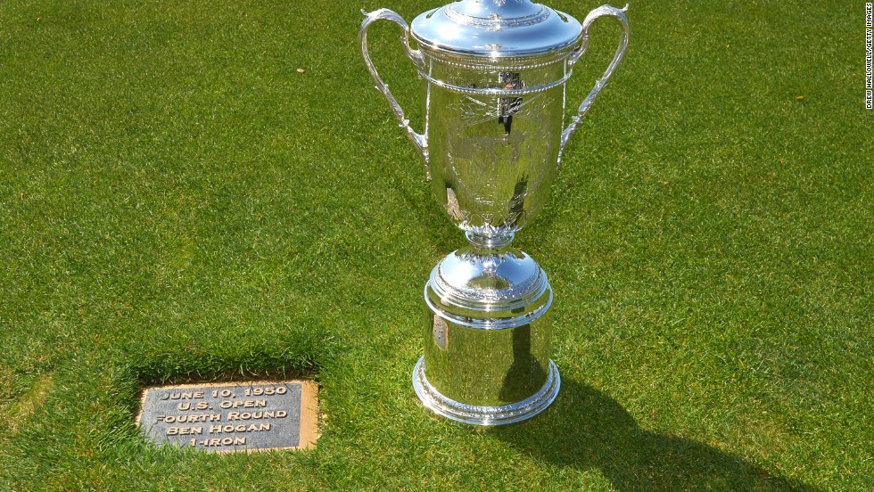 The U.S. Open trophy is paraded next to the plaque on the 18th hole which marks the point from which Hogan played his famous shot. 
