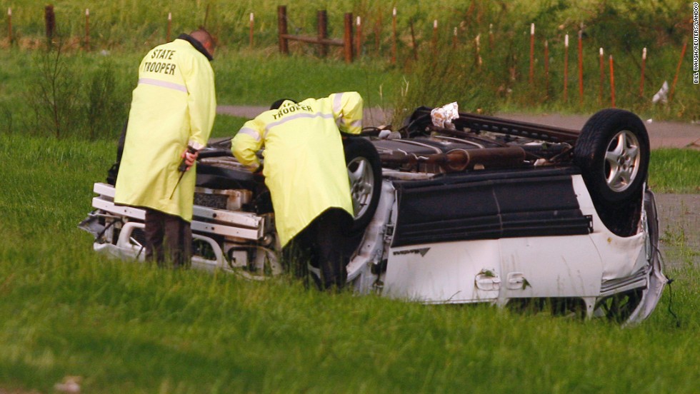 Oklahoma Highway Patrol Troopers inspect an overturned vehicle sitting alongside I-40 near El Reno on May 31.