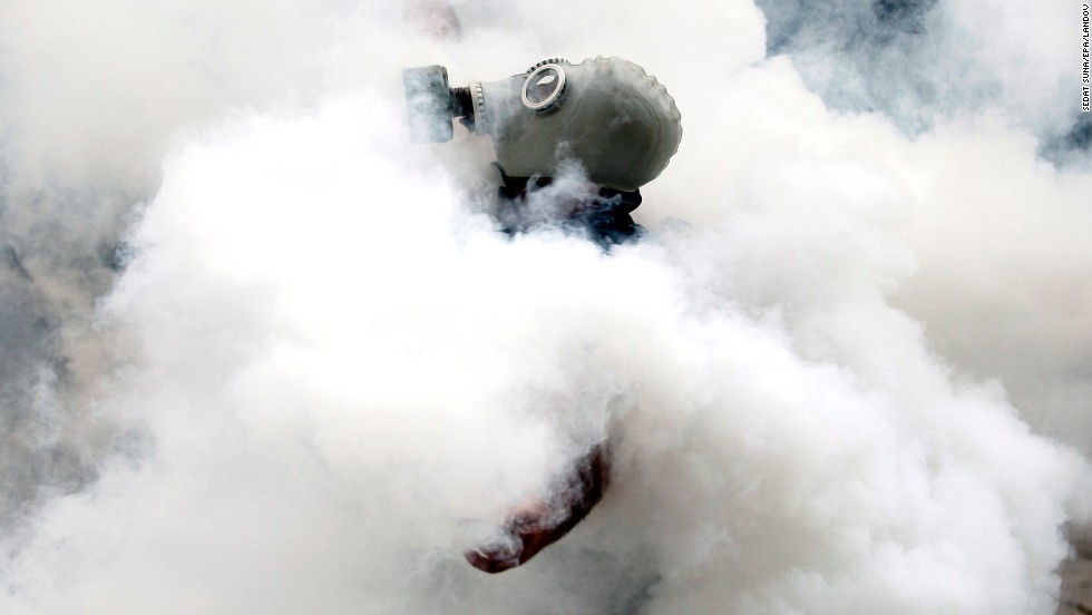 An activist wearing a gas mask is enveloped in a cloud of tear gas on May 31.