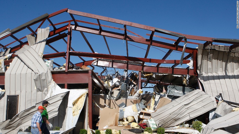 Two men walk by a damaged OKC-West Livestock Market building near El Reno on June 1. 