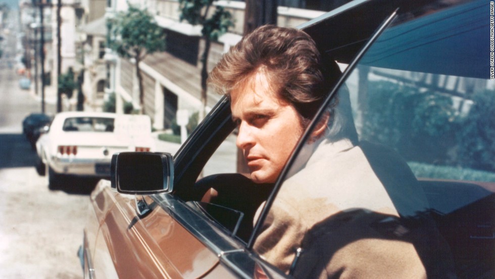 Douglas peers out of the window of a car as Inspector Steve Keller on &quot;Streets of San Francisco.&quot;