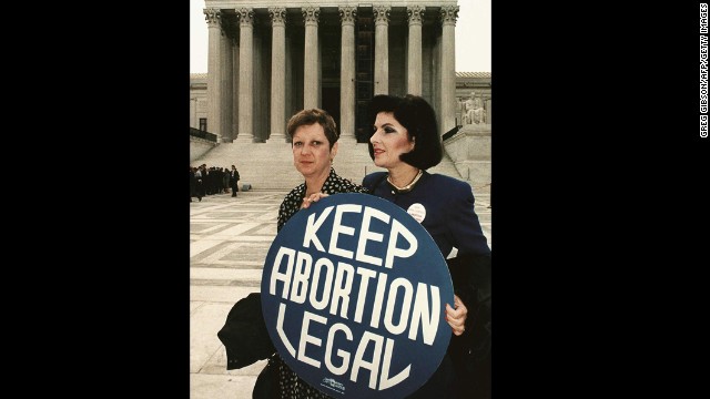 Norma McCorvey (L) formally known as &#39;Jane Roe,&#39; as she holds a pro-choice sign with former attorney Gloria Allred (R) in front of the US Supreme Court building in Washington, DC, just before attorneys began arguing the 1973 landmark abortion decision which legalized abortion in the US. 