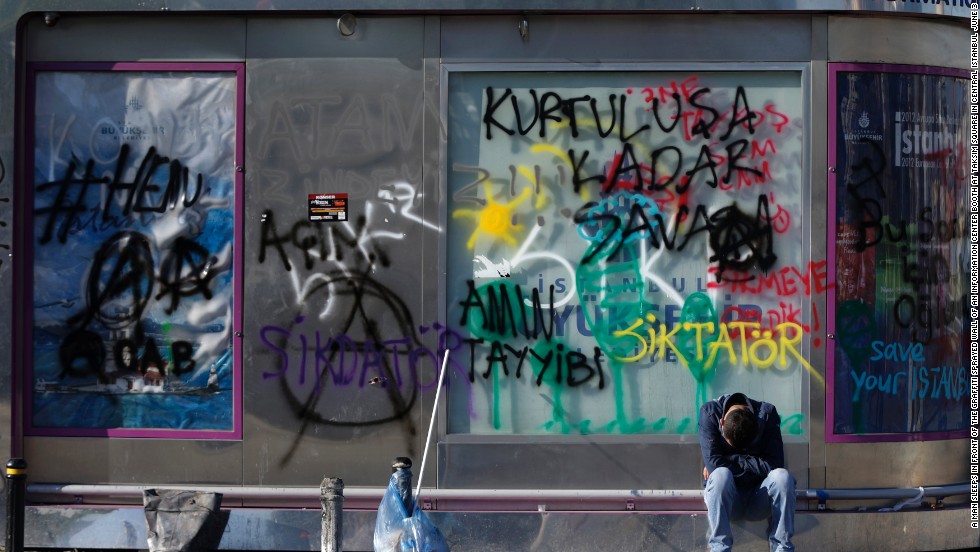 A tired protester rests in front of the graffiti-sprayed wall of an information booth at Taksim Square in central Istanbul on June 3.