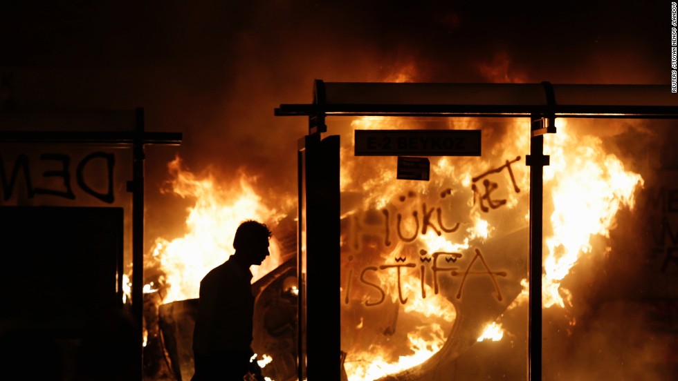 A protester is silhouetted by a burning car at Taksim Square during clashes in the early morning of June 3.