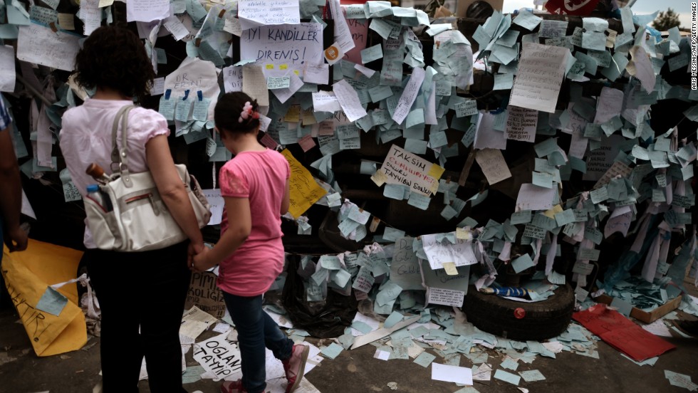 A mother and her daughter read notes placed by protestors on a destroyed car in Taksim Square on June 6. Thousands of striking union members joined the anti-government protests on June 5, marching in Istanbul and Ankara in a sea of red and white union flags, drumming and yelling for Prime Minister Recep Tayyip Erdogan to resign.