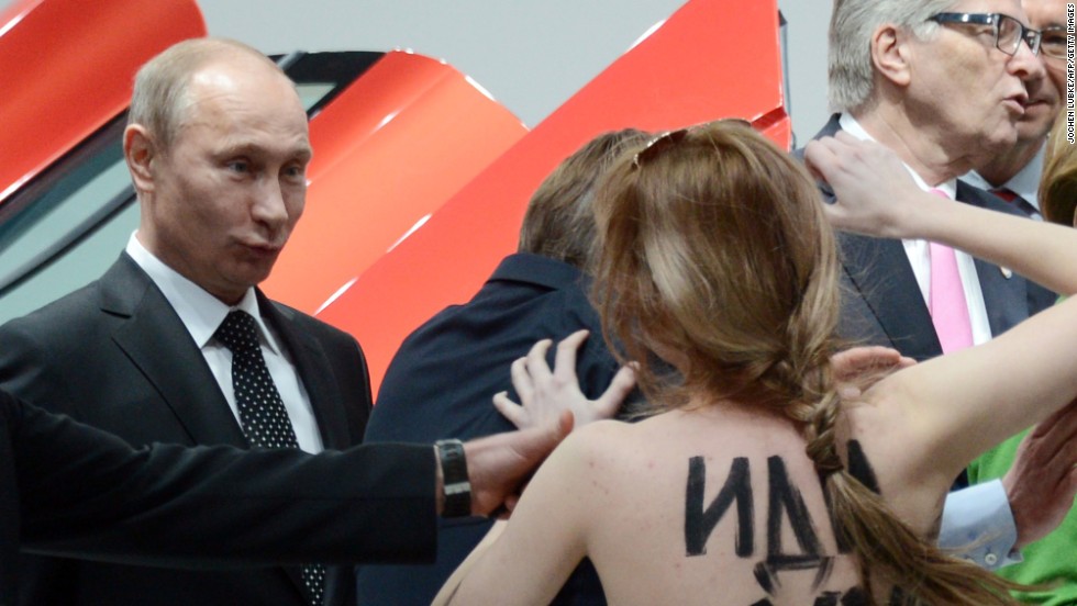 A topless protester shouts at Putin and German Chancellor Angela Merkel during a visit to the Hanover Industrial Fair in central Germany in April 2013. Human rights groups say civil liberties and democratic freedoms have suffered during Putin&#39;s rule.