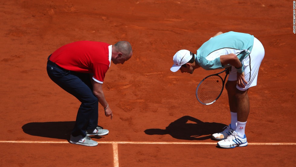 Umpire Pascal Maria checks a line call with Djokovic on June 7.