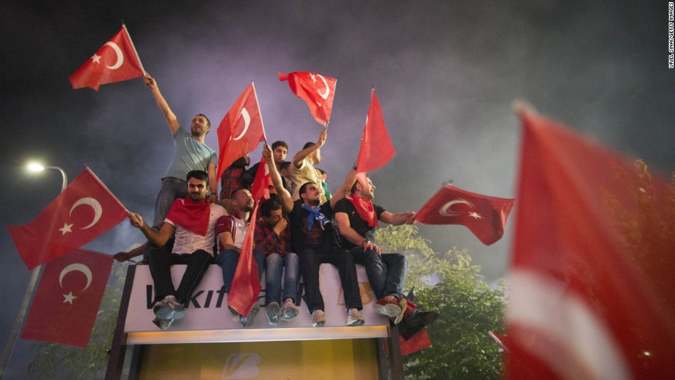 Supporters of Erdogan wave the Turkish flag upon the prime minister&#39;s arrival in Istanbul, on June 7.