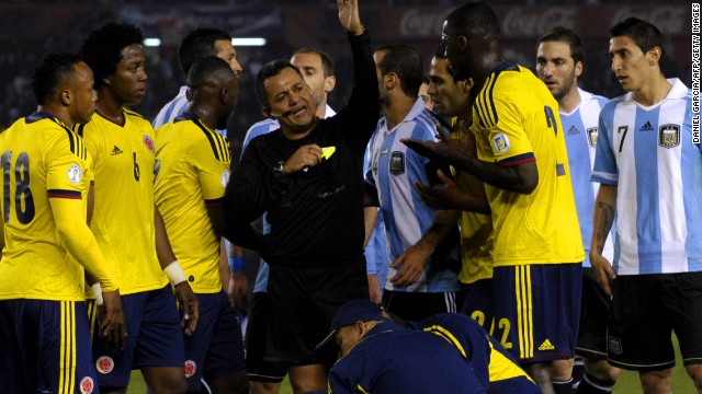 Referee Marlon Escalante battles to keep order between the Argentina and Colombia players in a stormy encounter. 