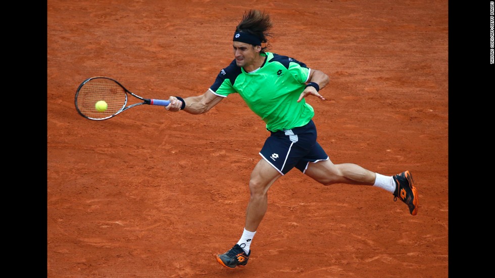 Ferrer returns a shot to Nadal.