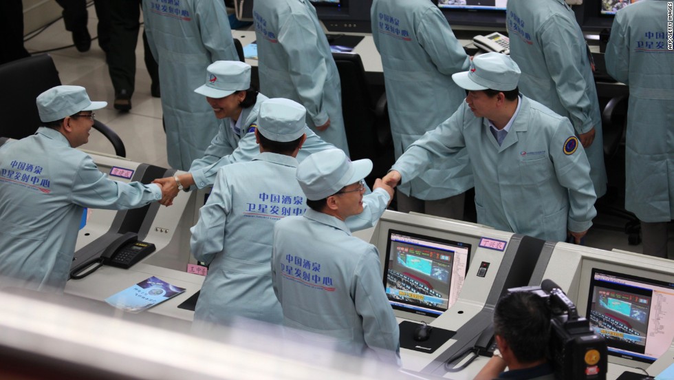 Chinese technicians congratulate each other after the Shenzhou-10 rocket successfully launched on June 11. This is expected to be China&#39;s longest flight with astronauts on board. 