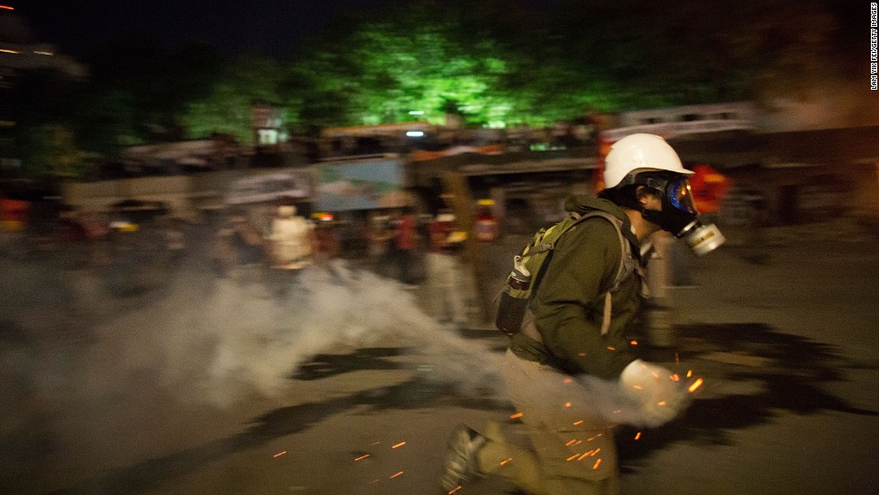 A protester prepares to throw a tear gas canister back toward police in Taksim Square on Tuesday, June 11.
