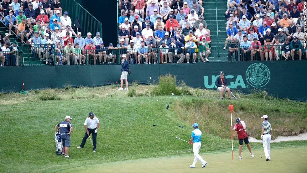 Jason Day of Australia, Rickie Fowler of the United States and Matteo Manassero of Italy play on the 17th green on June 13.