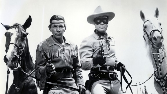 The Lone Ranger, played by Clayton Moore, right, and his Native American partner, Tonto, played by Jay Silverheels, pose with their trusty steeds.
