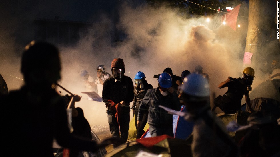 Protesters scramble for safety as Turkish riot police officers push them out of Gezi Park using tear gas and rubber bullets.  