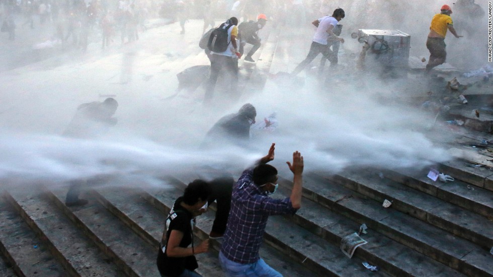 Protesters run for cover as riot police spray them with a water cannon on June 15. 