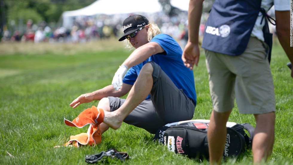 Charley Hoffman dries his feet after chipping to the fourth green from a creek  during the third round on June 15. 