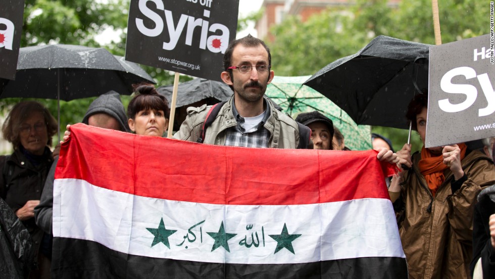 A man holds a Syrian flag outside the U.S. Embassy in London on Saturday, June 15, during a demonstration against Western involvement in the Syria conflict. 