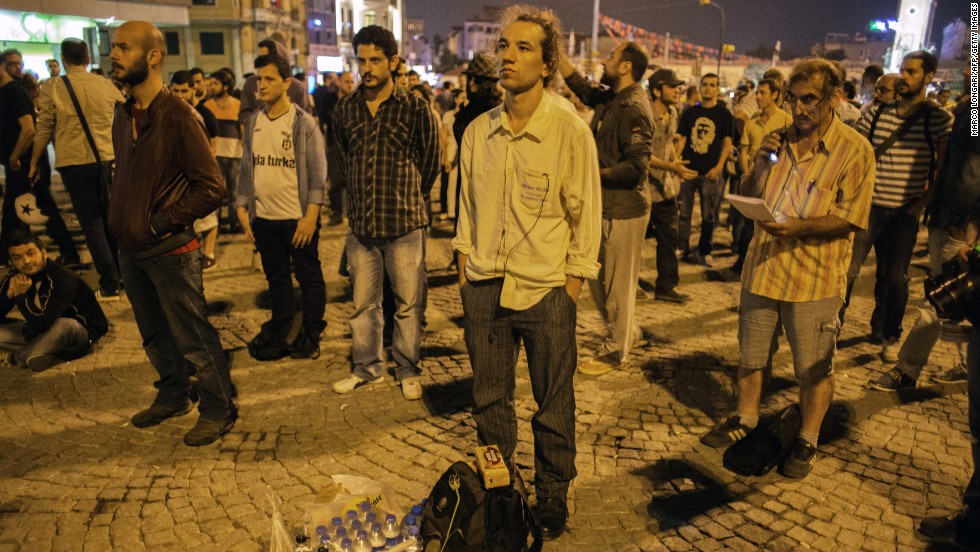 Turkish performance artist Erdem Gunduz, center, is joined by others as he makes his silent protest in Taksim Square. As word of his gesture of protest spread, Gunduz became known as the &quot;standing man.&quot; Protests that began as a &lt;a href=&quot;http://www.cnn.com/2013/06/17/world/europe/turkey-protests/index.html&quot;&gt;demonstration against the planned demolition of a park&lt;/a&gt; have grown into general anti-government dissent across the nation. 