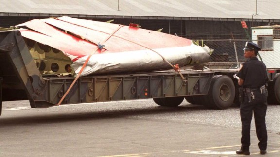 A police officer stands guard as part of the plane is transported from a dock in Brooklyn, New York, on July 19, 1996.