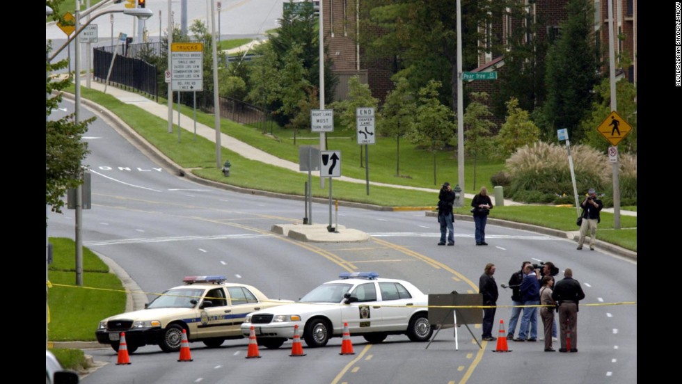 A stretch of road where 40-year-old bus driver Conrad Johnson was shot and killed is blocked off in Aspen Hill, Maryland, on October 22, 2002. Johnson was the last victim of the Beltway sniper attacks.