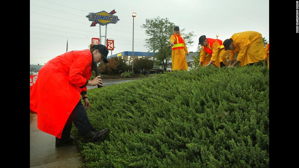 Police search the grounds near a Sunoco gas station in Manassas, Virginia, where Dean Harold Meyers, 53, was shot and killed on October 10, 2002. 