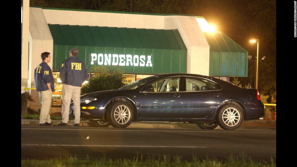 Two FBI agents stand in front of a Ponderosa restaurant in Ashland, Virginia, where Jeffrey Hopper was shot on October 19, 2002. The 37-year-old was shot in the stomach while walking with his wife in the parking lot. He survived.