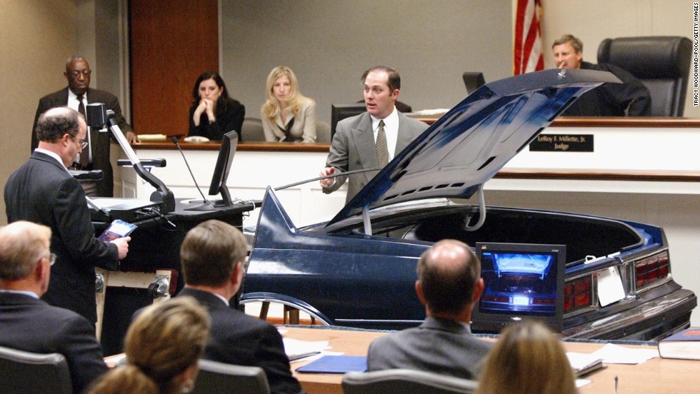 During the trial of Muhammad in November 2003, FBI visual information specialist Wynn Gregory Warren points to a hole cut in the trunk of a Chevrolet Caprice. The suspects had used the vehicle as a rolling sniper&#39;s nest, prosecutors said.