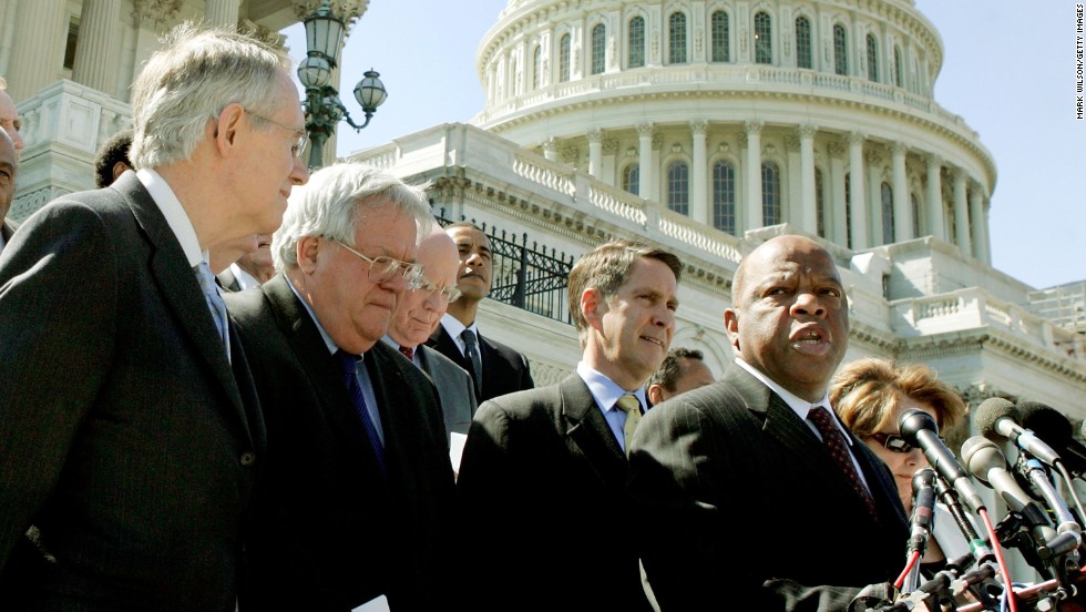 Rep. John Lewis speaks after bipartisan House and Senate officials met to voice support for reauthorizing the Voting Rights Act for an additional 25 years on May 2, 2006. From left, Senate Minority Leader Harry Reid, House Speaker Dennis Hastert, Senate Majority Leader Bill Frist and other officials listen during the media conference.