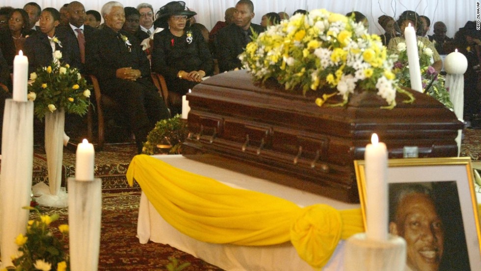 Mandela sits with his wife, Graca Machel, and his grandchildren at his son&#39;s funeral on January 15, 2005.  He disclosed that his son, Makgatho Lewanika Mandela, had died of AIDS and said the disease should be given publicity so people would stop viewing it as extraordinary.