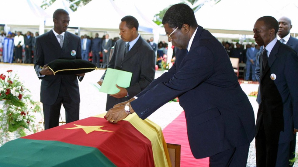 Then Prime Minister Peter Musonge lays a posthumous medal -- the Commander of the National Order of Valor -- on Foe&#39;s coffin at his burial in Yaounde. 