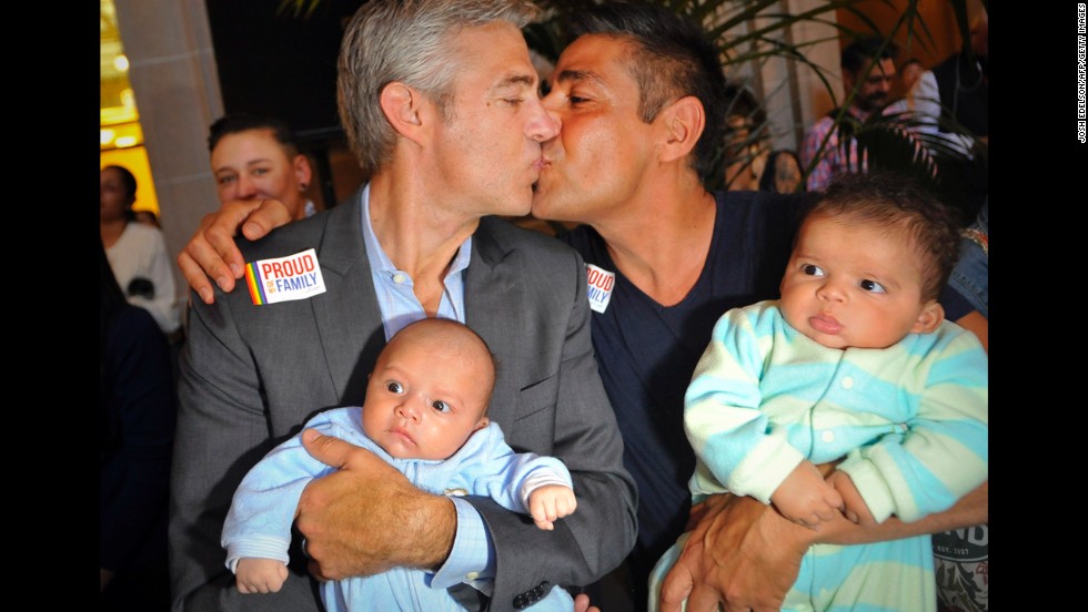 Chris Roe, left, and Roby Chavez celebrate while holding their soon-to-be-adopted children as the ruling is announced in San Francisco.