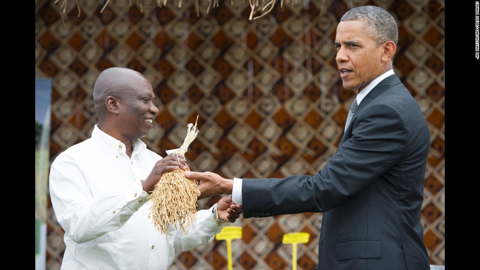 Obama shows the White House press corps what rice looks like before it&#39;s threshed on June 28 in Dakar.
