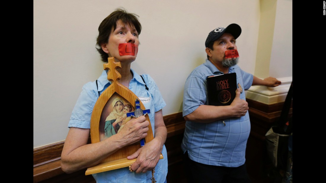 Anti-abortion demonstrators taped the word &quot;life&quot; over their mouths as they stood in the rotunda of the state Capitol in July 2013.