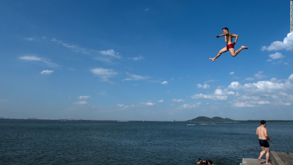 A man jumps into East Lake in Wuhan, the capital of central China&#39;s Hubei Province, on Wednesday, July 3.