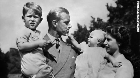 Queen Elizabeth II and Prince Philip, the Duke of Edinburgh, with a young Prince Charles and a baby Princess Anne.