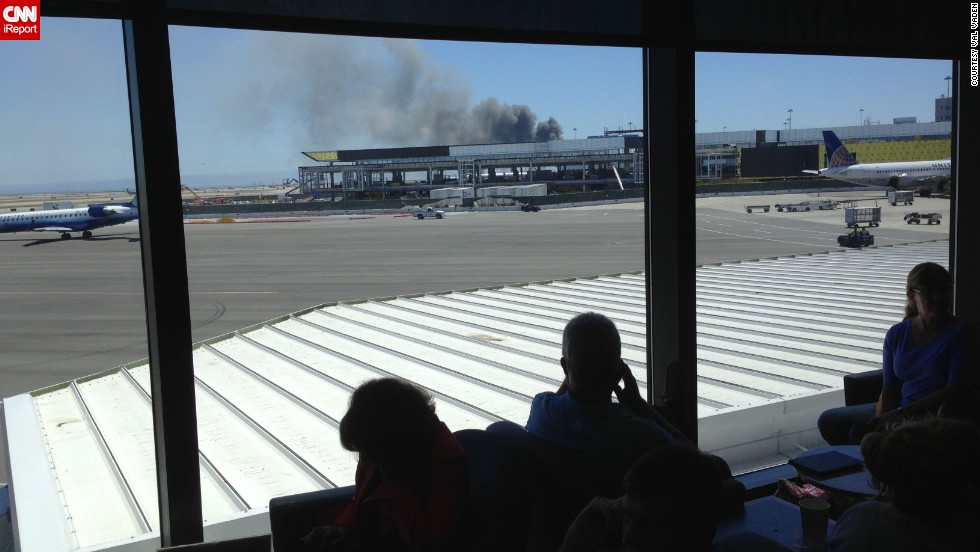 iReporter Val Vaden captured this photo while waiting in a departure lounge at the San Francisco airport on July 6. Val observed the billowing smoke and emergency responders&#39; rush in. 