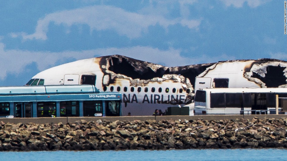 Airport shuttles arrive on the scene after the crash landing.