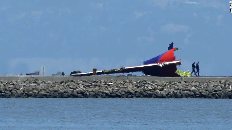 People walk past the wreckage of the plane&#39;s tail on July 6.