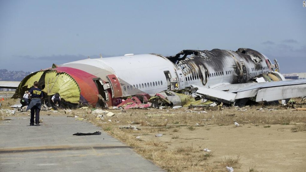 An investigator stands near the tail of the plane in a handout photo released on July 7. The NTSB has ruled out weather as a problem and said that conditions were right for a &quot;visual landing.&quot;